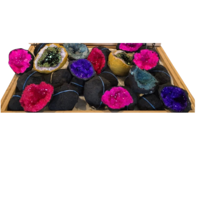 Assorted brightly dyed geode halves with sparkling crystal interiors shown in a wooden display