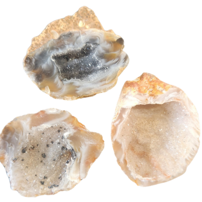 Three mini geode halves showing sparkling crystal-lined interiors and natural stone edges